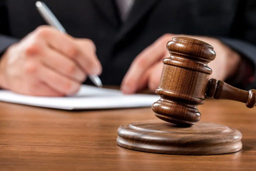 Lawyer writing with gavel on table | Family Lawyer | The Hemmat Law Group