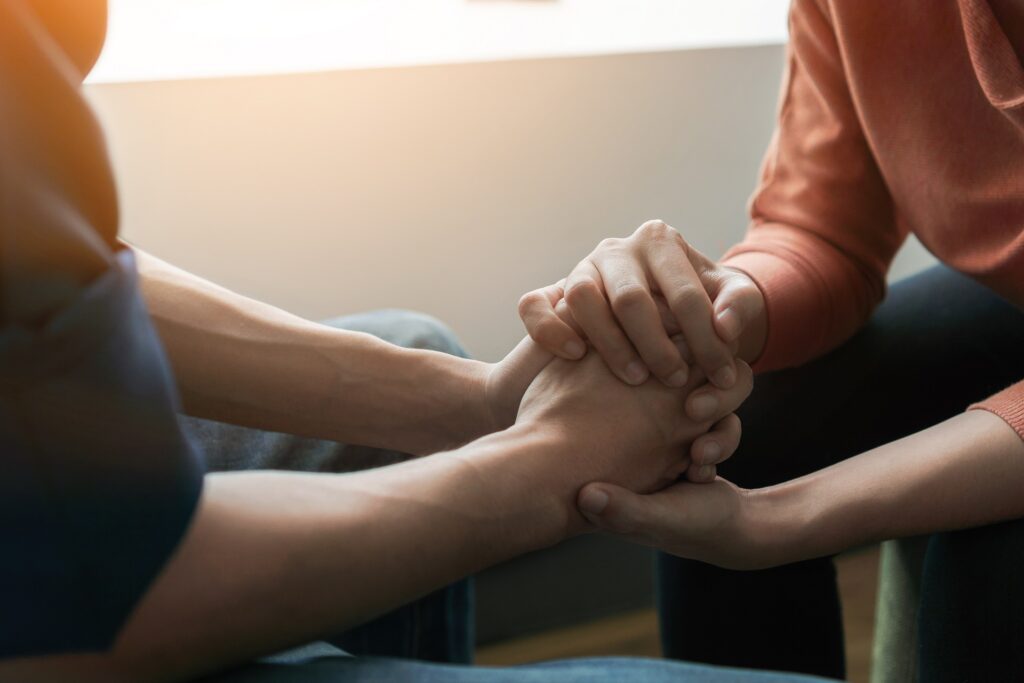 Two People Holding Hands in a Supportive Manner  | Family Lawyer | Hemmat Law Group