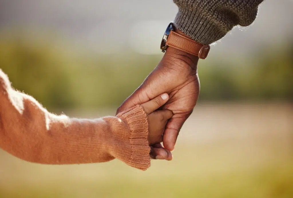 Hand gently holding a smalle hand | Child Custody Lawyer | The Hemmat Law Group