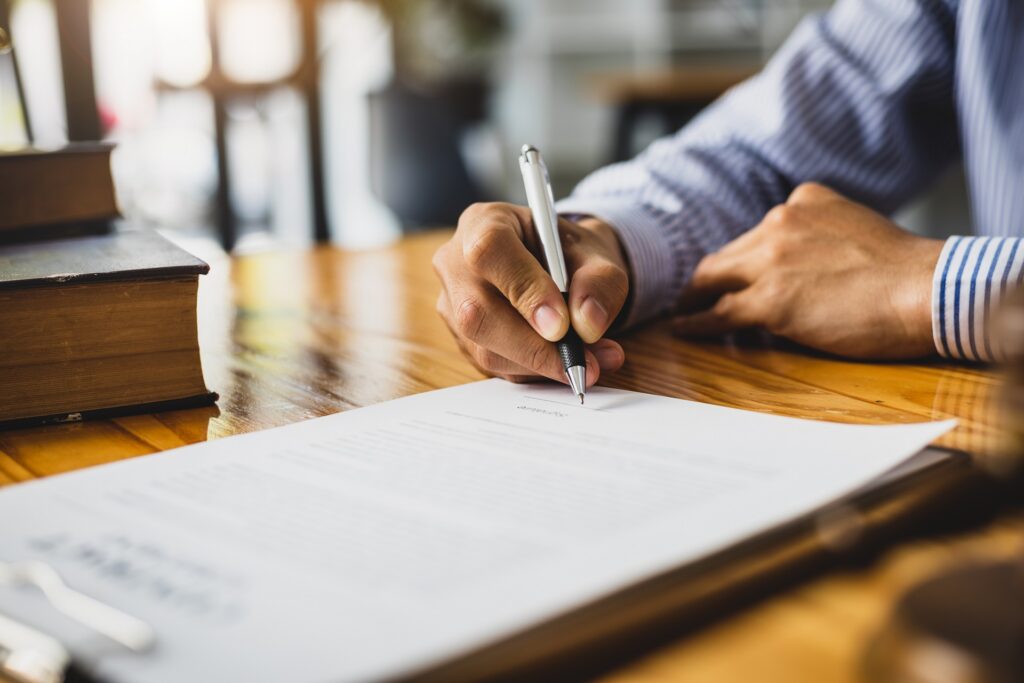 A Person Signing a Document on a Table | Divorce Attorney Seattle | Hemmat Law Group