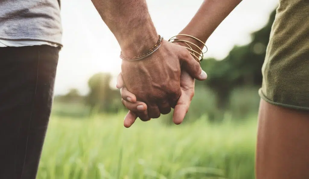 Two People Holding Hands in a Field at Sunset | Domestic Violence Lawyer | The Hemmat Law Group