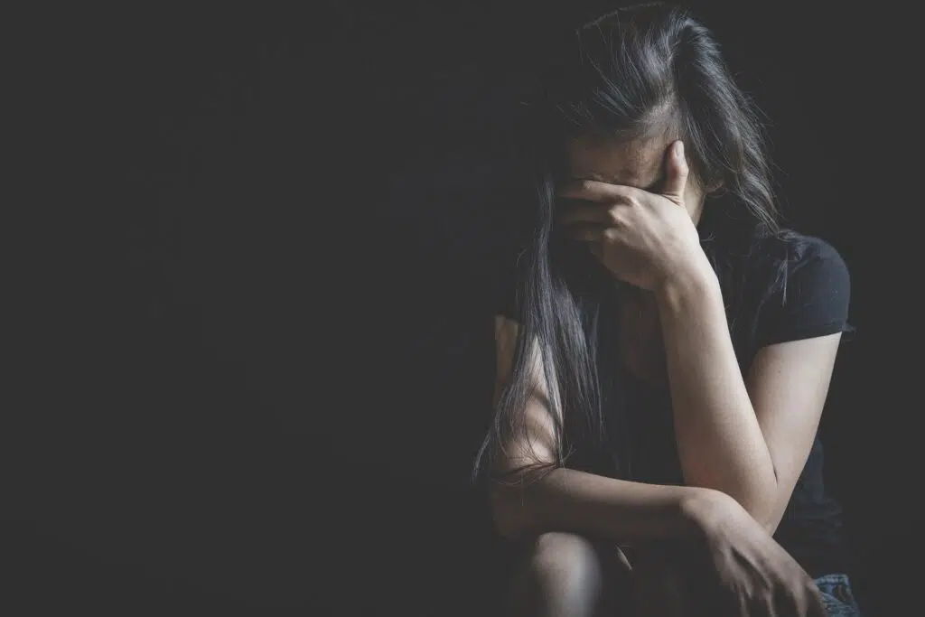A Woman Hides Her Face in the Dark | Domestic Violence Lawyer | The Hemmat Law Group