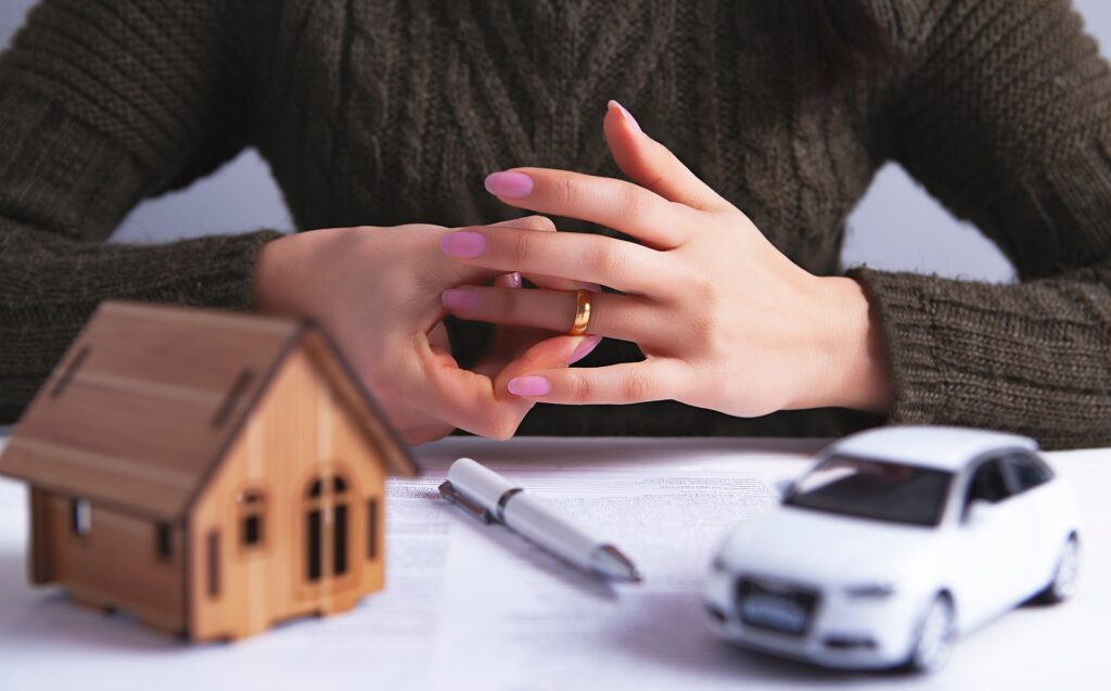 A Woman with Miniature Figures of Car and House | Divorce Lawyer Seattle | Hemmat Law Group
