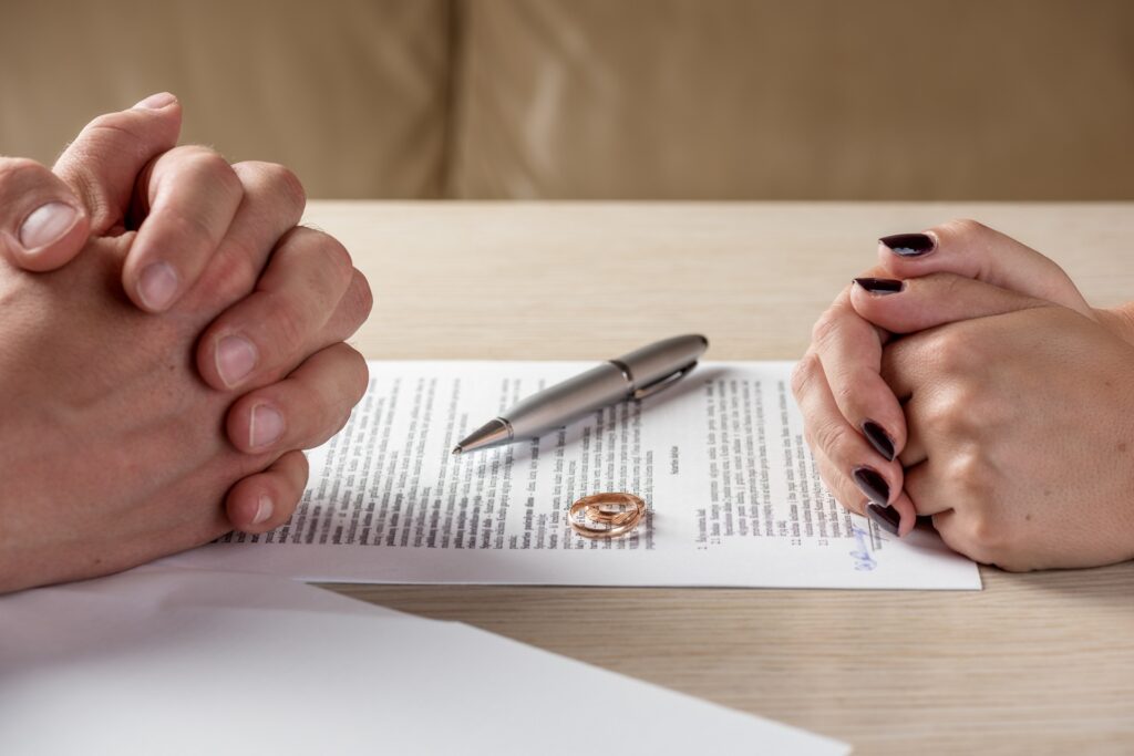 Two People with Interlocked Hands at a Table | Divorce Attorney Seattle | Hemmat Law Group