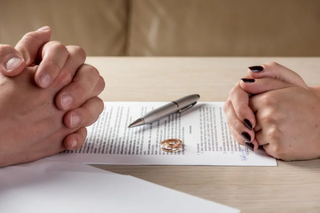 Two People with Interlocked Hands at a Table | Divorce Attorney Seattle | The Hemmat Law Group