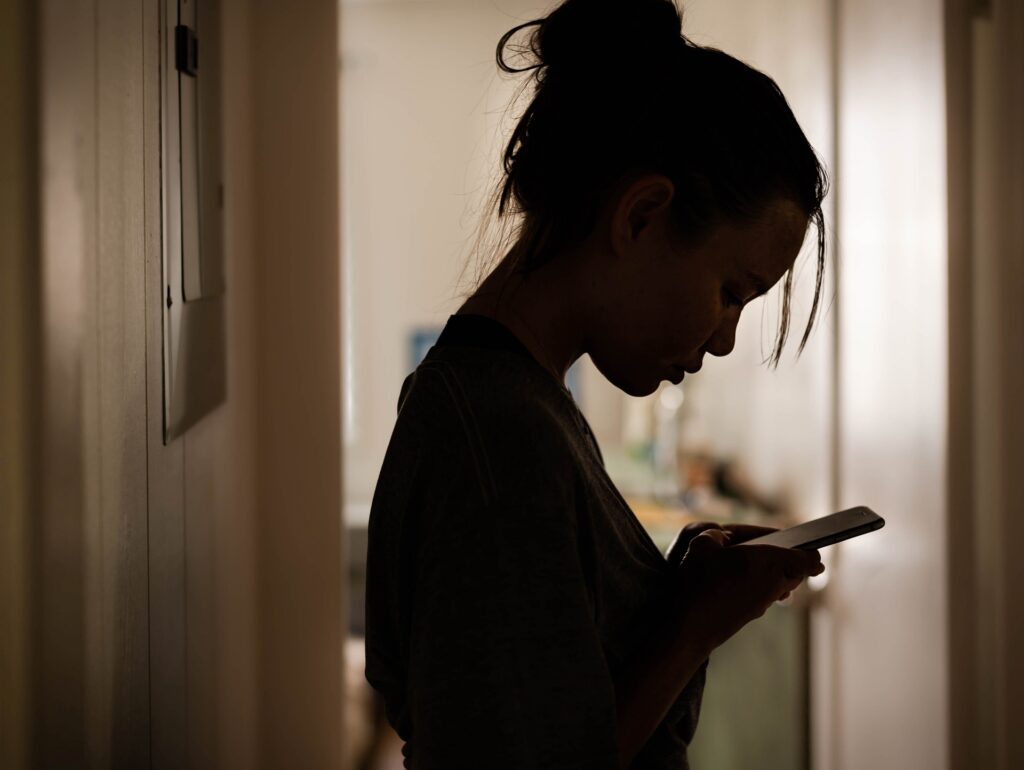 A Woman Scrolling Through Her Smartphone | Domestic Violence Lawyer | Hemmat Law Group