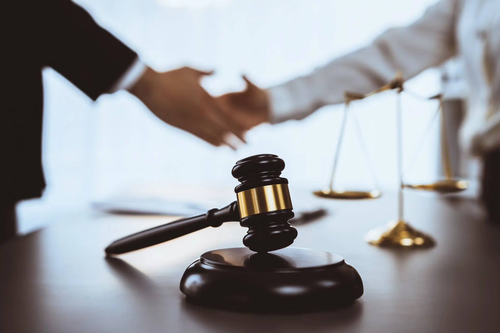 A gavel rests as two shake hands, symbolizing agreement | Divorce Lawyer | The Hemmat Law Group