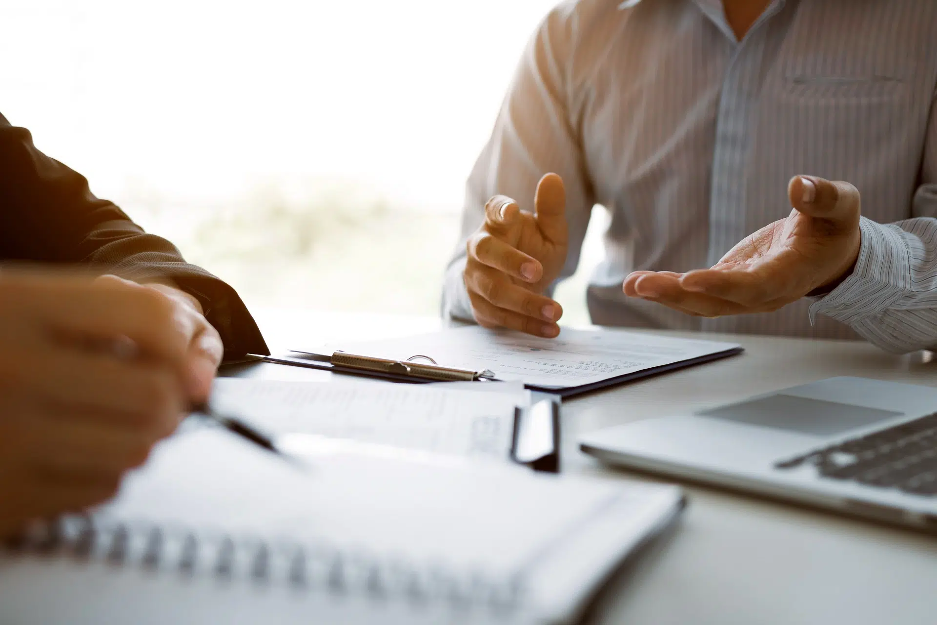 Two people discussing documents at a table | Domestic Violence Law | The Hemmat Law Group