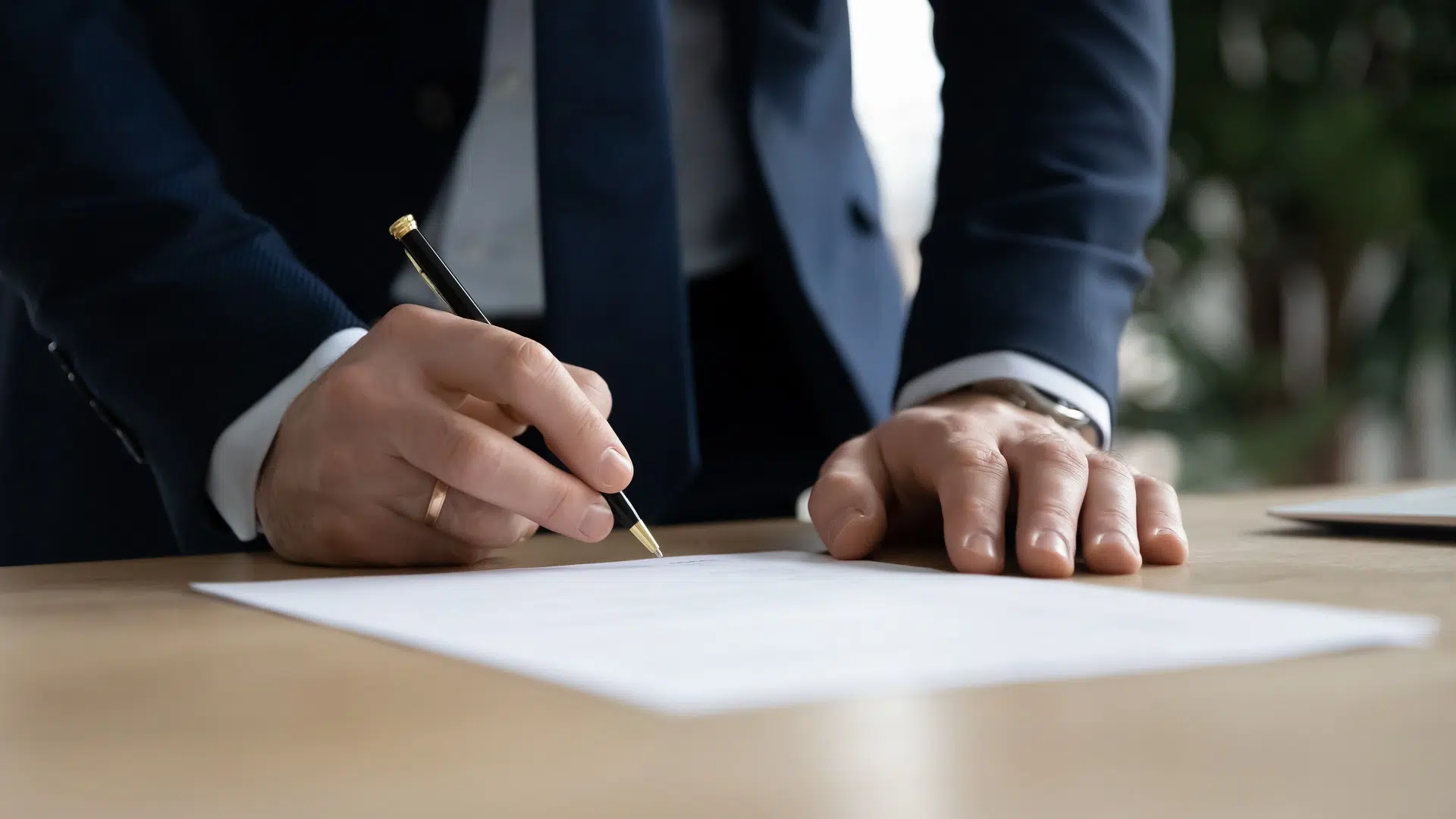 Man in suit signing a document | Domestic Violence Lawyer | The Hemmat Law Group