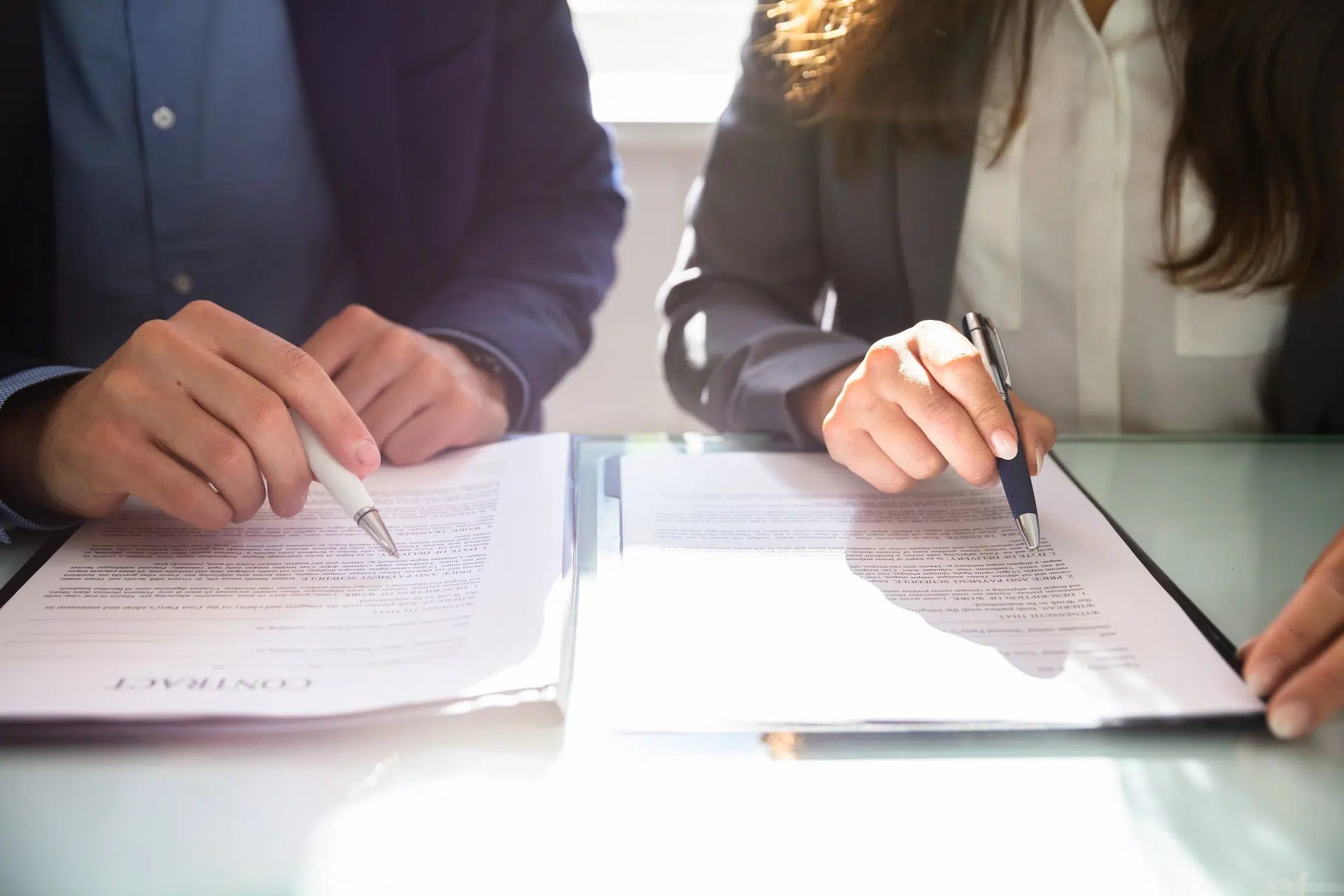 Two people signing legal contracts at a table | Divorce Lawyer Seattle | The Hemmat Law Group