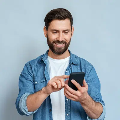 Smiling man with a beard using a smartphone | family lawyer seattle | The Hemmat Law Group