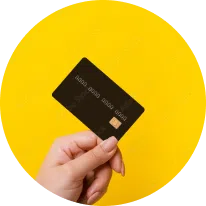 Hand holding a credit card against a bright yellow background | Family Lawyer | The Hemmat Law Group