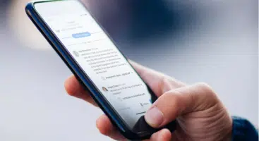 Hand holding and using a smartphone to view messages | family law attorney | The Hemmat Law Group