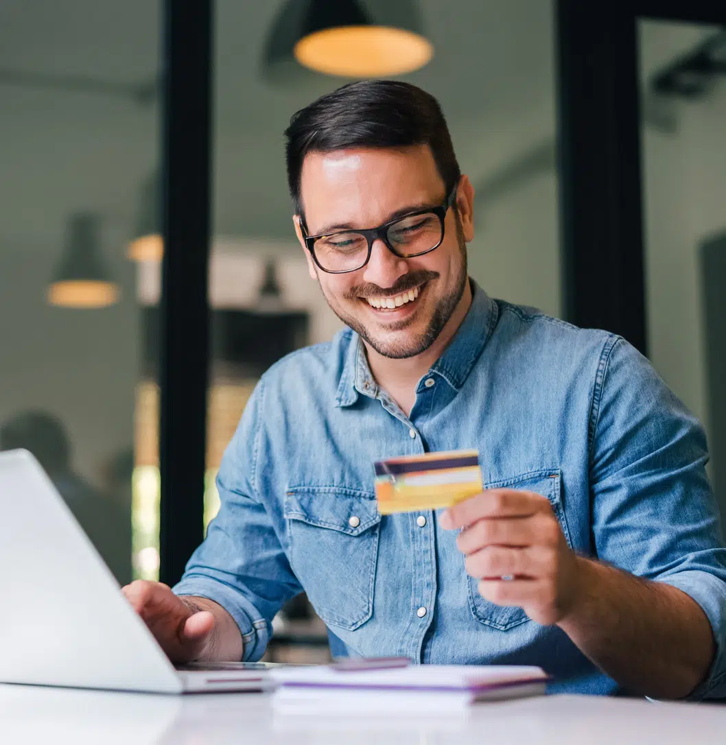 Smiling man with glasses holding a credit card | child custody lawyer | The Hemmat Law Group