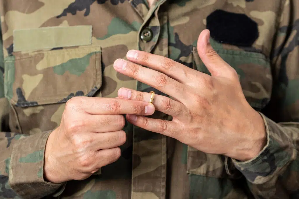 Person in military uniform removing wedding ring | Divorce Lawyer | The Hemmat Law Group