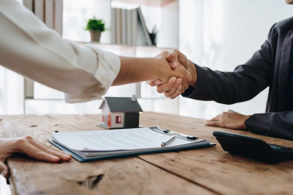 People shaking hands over documents | mediation services | The Hemmat Law Group