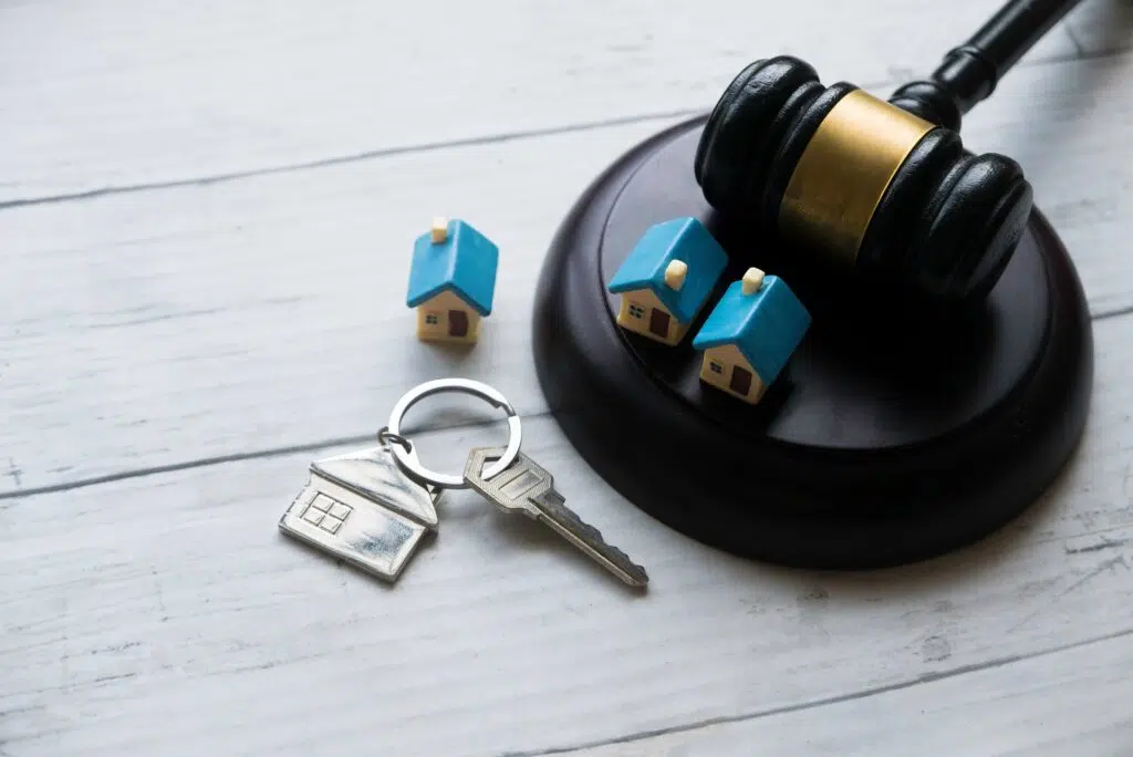 Gavel, toy houses, and keys on a wooden surface | Divorce Lawyer | The Hemmat Law Group