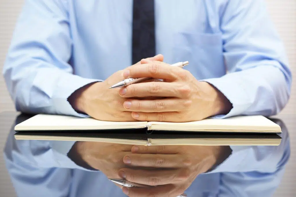 A close-up of a businessman’s hands clasped | Mediation Services  | The Hemmat Law Group