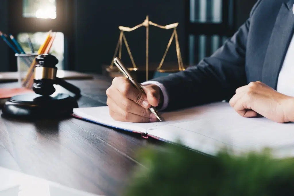 Lawyer signing legal documents at desk | Threats And Intimidation | The Hemmat Law Group