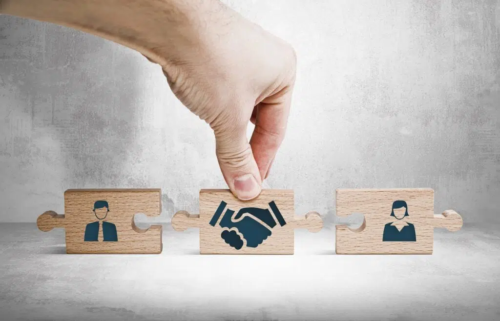Hand connecting puzzle pieces with people and a handshake | Divorce Lawyer | The Hemmat Law Group