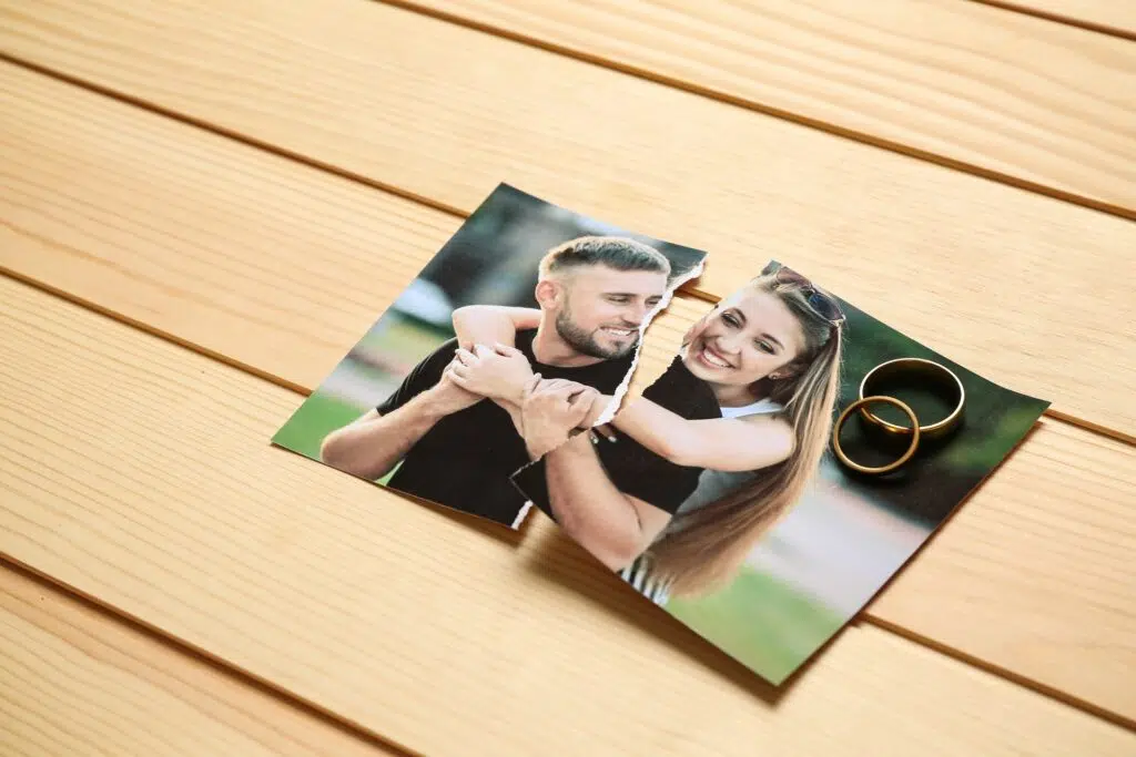 Torn photo of a smiling couple with two wedding rings | Divorce Lawyer | The Hemmat Law Group