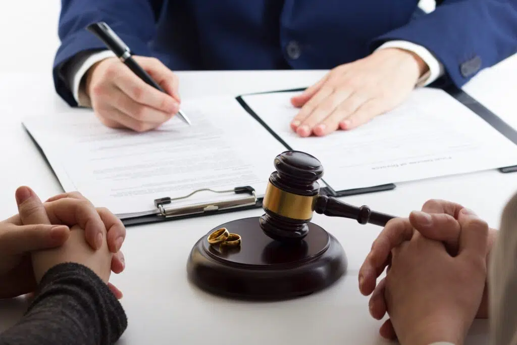 Hands near a gavel and wedding rings on divorce papers | Divorce Lawyer | The Hemmat Law Group