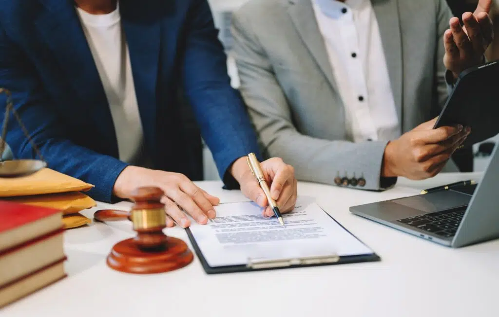 People signing legal documents with law books & a gavel | Divorce Lawyer | The Hemmat Law Group