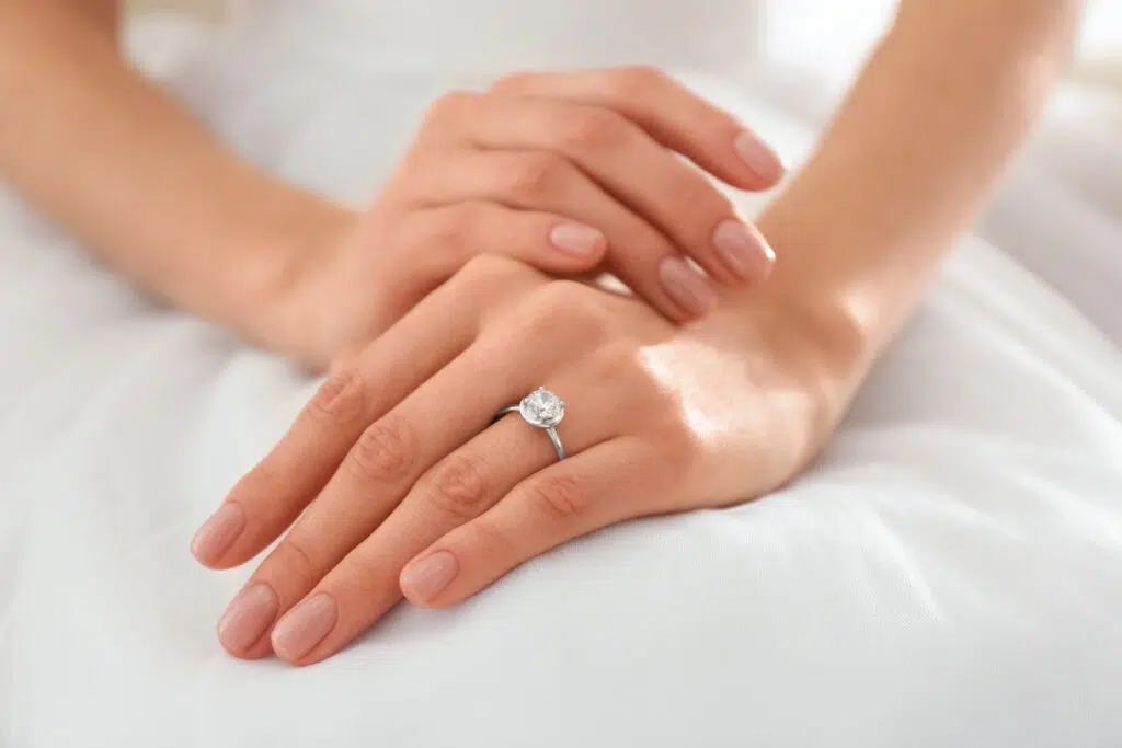 Close-up of a bride's hands resting on a white satin surface | Divorce Lawyer | The Hemmat Law Group