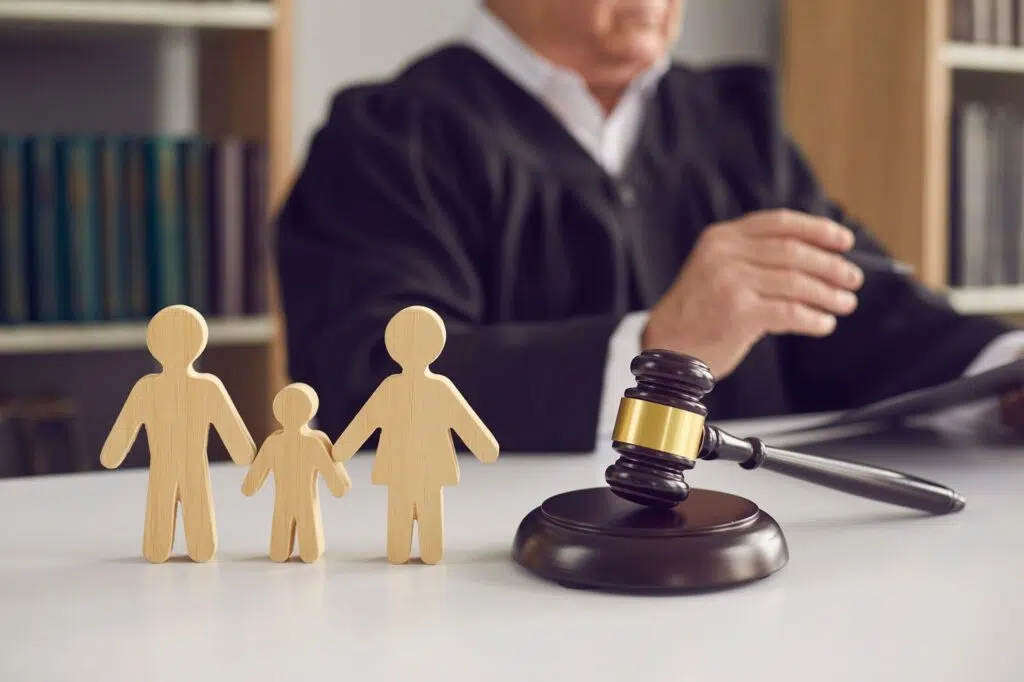 A judge sits with a gavel and wooden family figures | Divorce Lawyer | The Hemmat Law Group