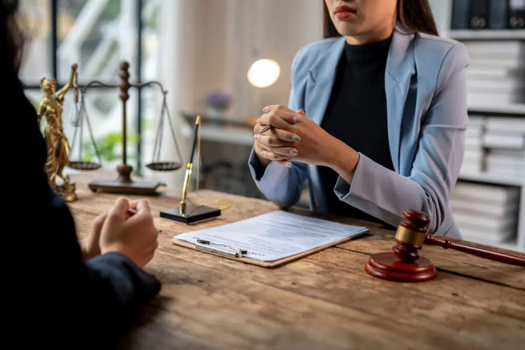 A lawyer in a light blue blazer consults a client | Child Custody Lawyer | The Hemmat Law Group
