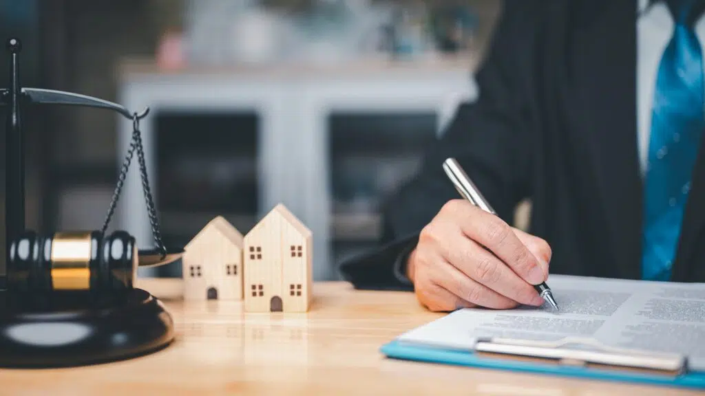 Lawyer in a suit writes on a document | High Asset Divorce Lawyer Seattle | The Hemmat Law Group
