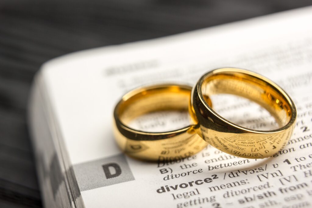 Two wedding rings sit on a dictionary above the definition of the word divorce.