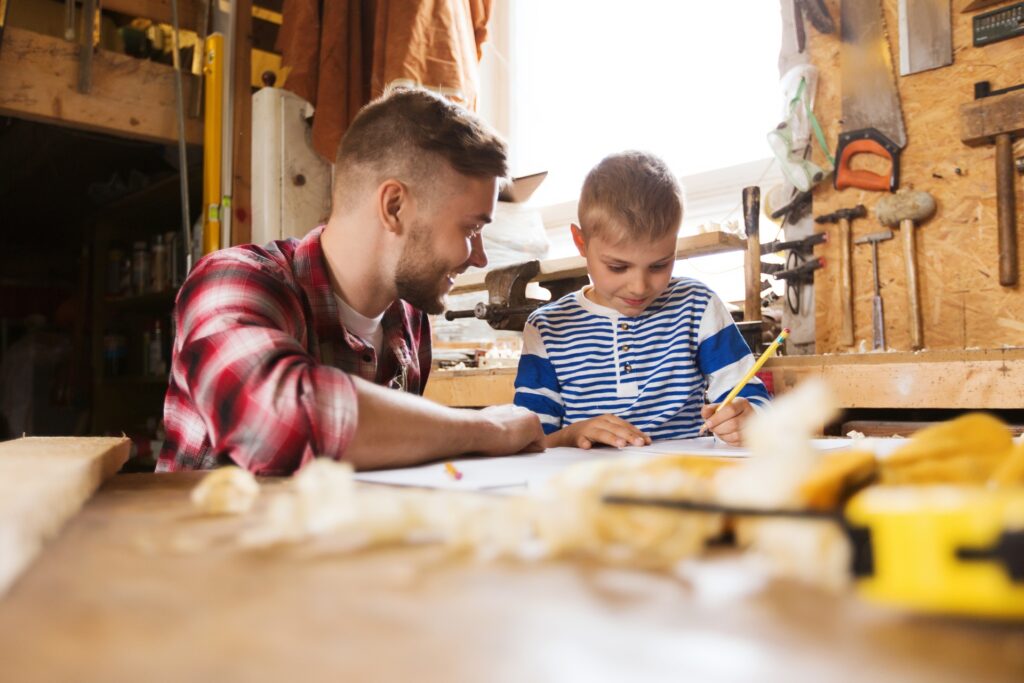 A man sits with his son playing games at a table.