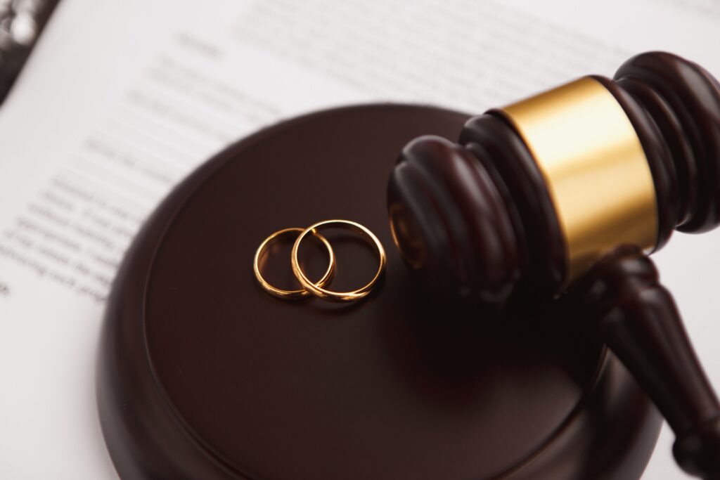 Two wedding rings sit next to a gavel resting on its stand.