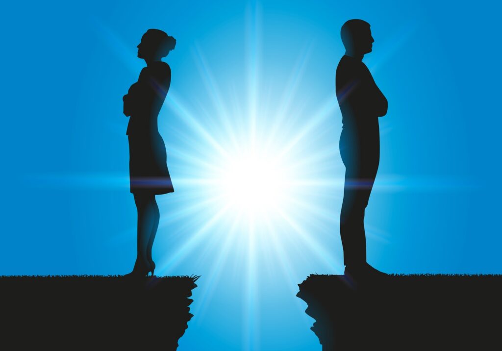 The silhouette of two people standing on the edge of two cliffs with their backs facing each other.