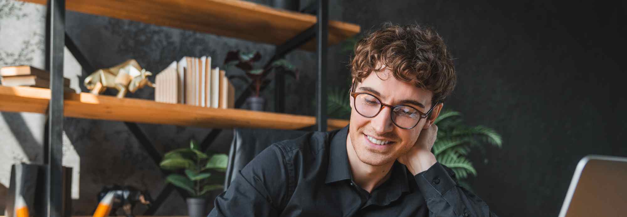Man in glasses smiling at laptop in office | Hemmat Law Group