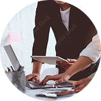 Business colleagues reviewing documents around a laptop | Hemmat Law Group