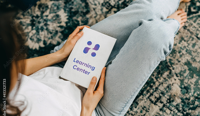 Person holding a Learning Center booklet while sitting down | Hemmat Law Group