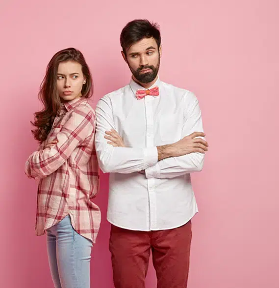 Unhappy couple standing apart with arms crossed during conflict | Hemmat Law Group