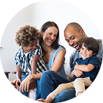 Happy family of four sitting closely together and smiling | Hemmat Law Group