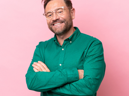 Smiling man in green shirt standing with crossed arms | Hemmat Law Group