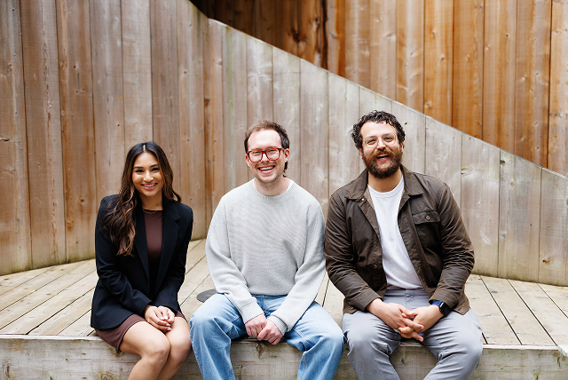 Three colleagues sitting together on a wooden bench | Hemmat Law Group