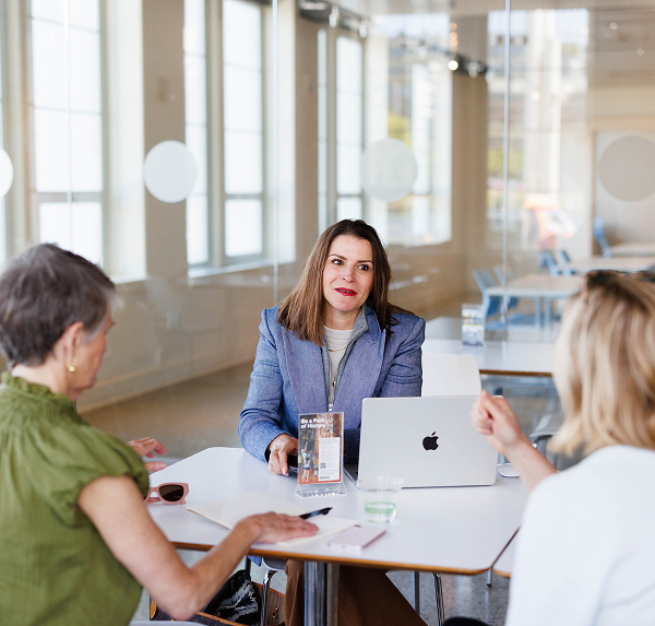 Professional woman meeting with two clients at a table | Hemmat Law Group