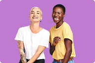 2 women laughing together against a purple background | Hemmat Law Group