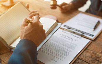Legal documents and notebook arranged on an office desk | Hemmat Law Group