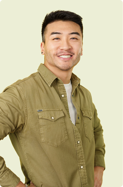 Smiling man in green shirt posing against light backdrop | Hemmat Law Group