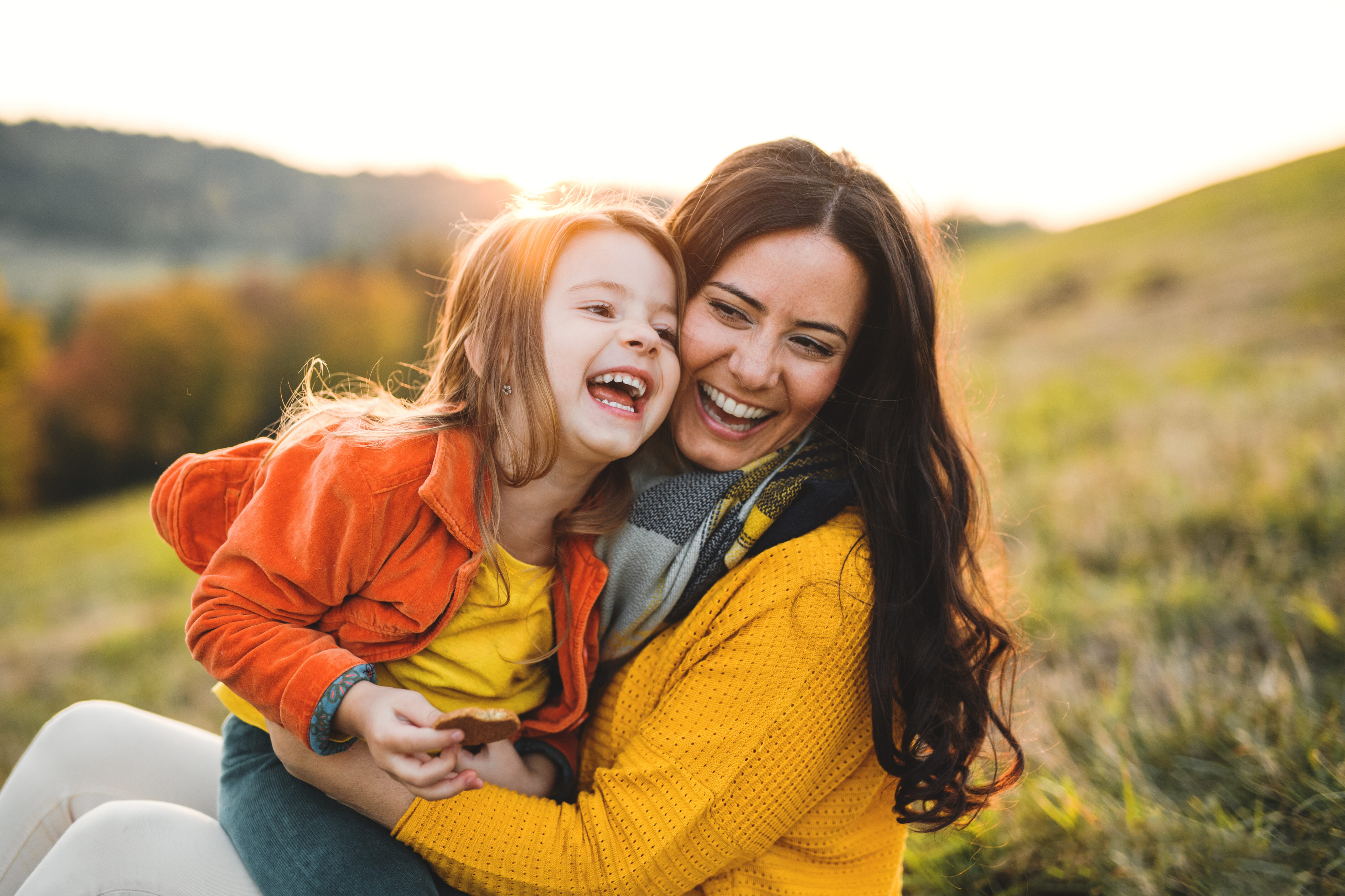 Mother and daughter laughing together outdoors | Hemmat Law Group