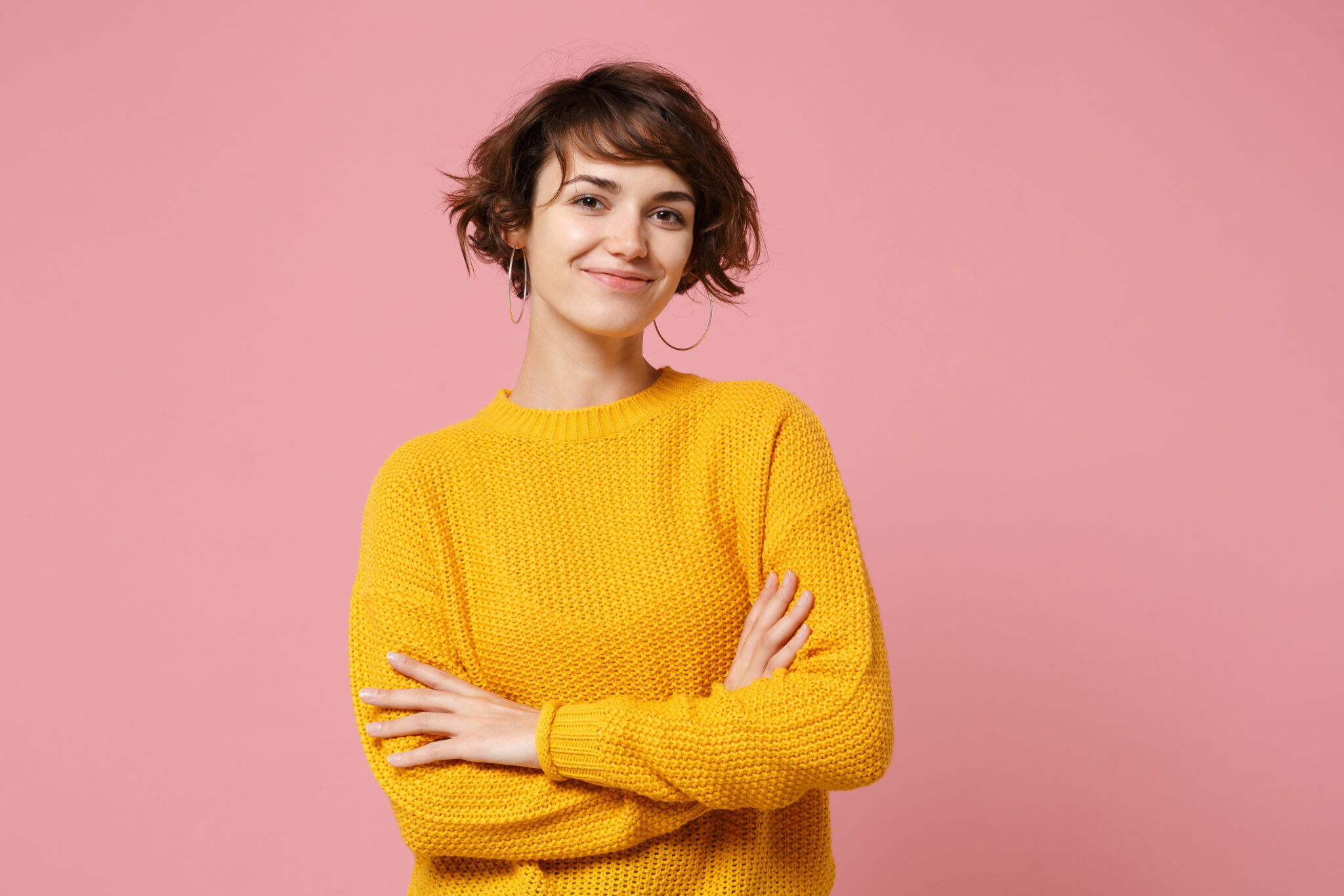 Smiling woman in yellow sweater against a pink background | Hemmat Law Group