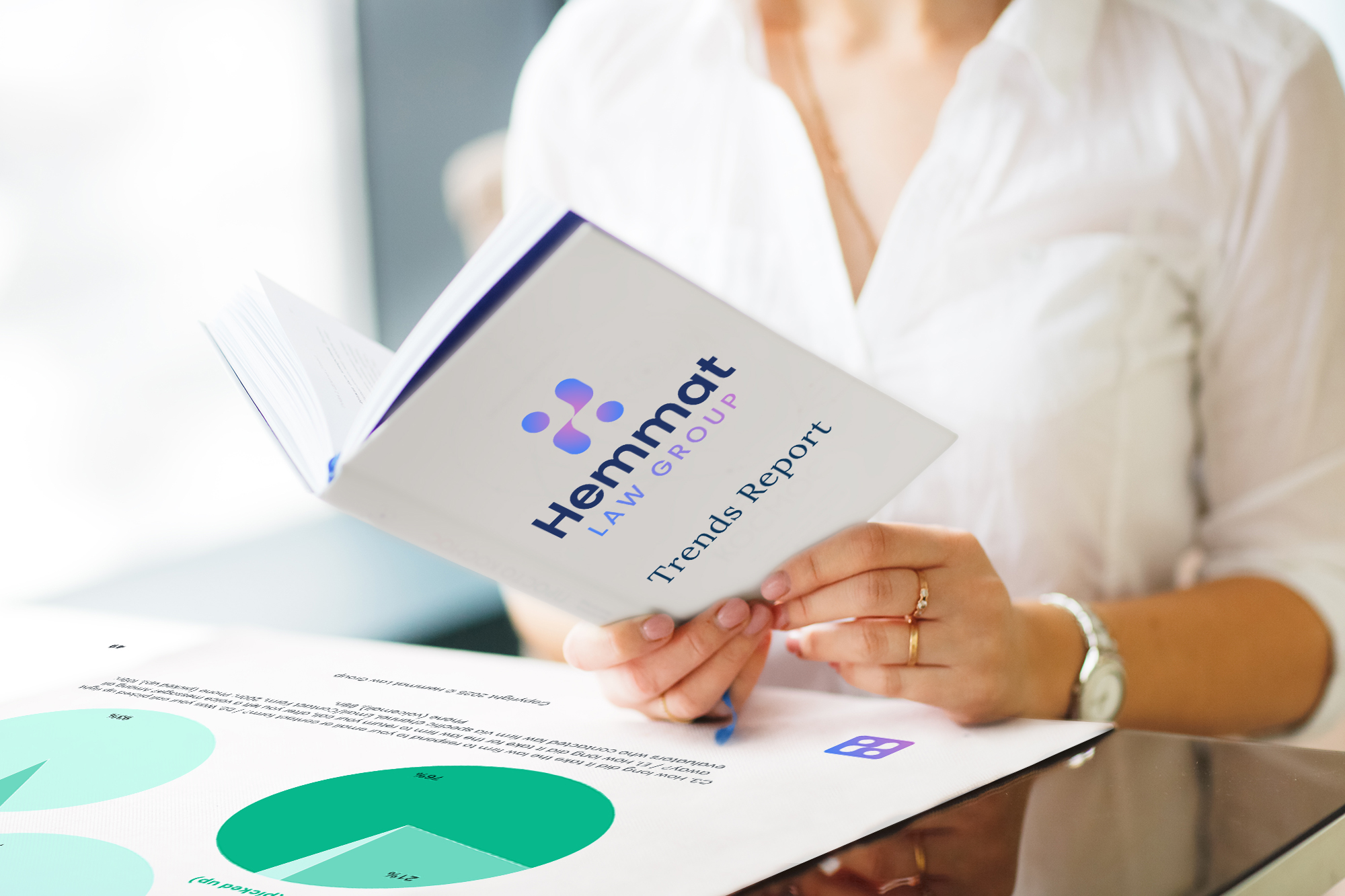 Person reviewing a Hemmat Law Group Trends Report booklet | Hemmat Law Group