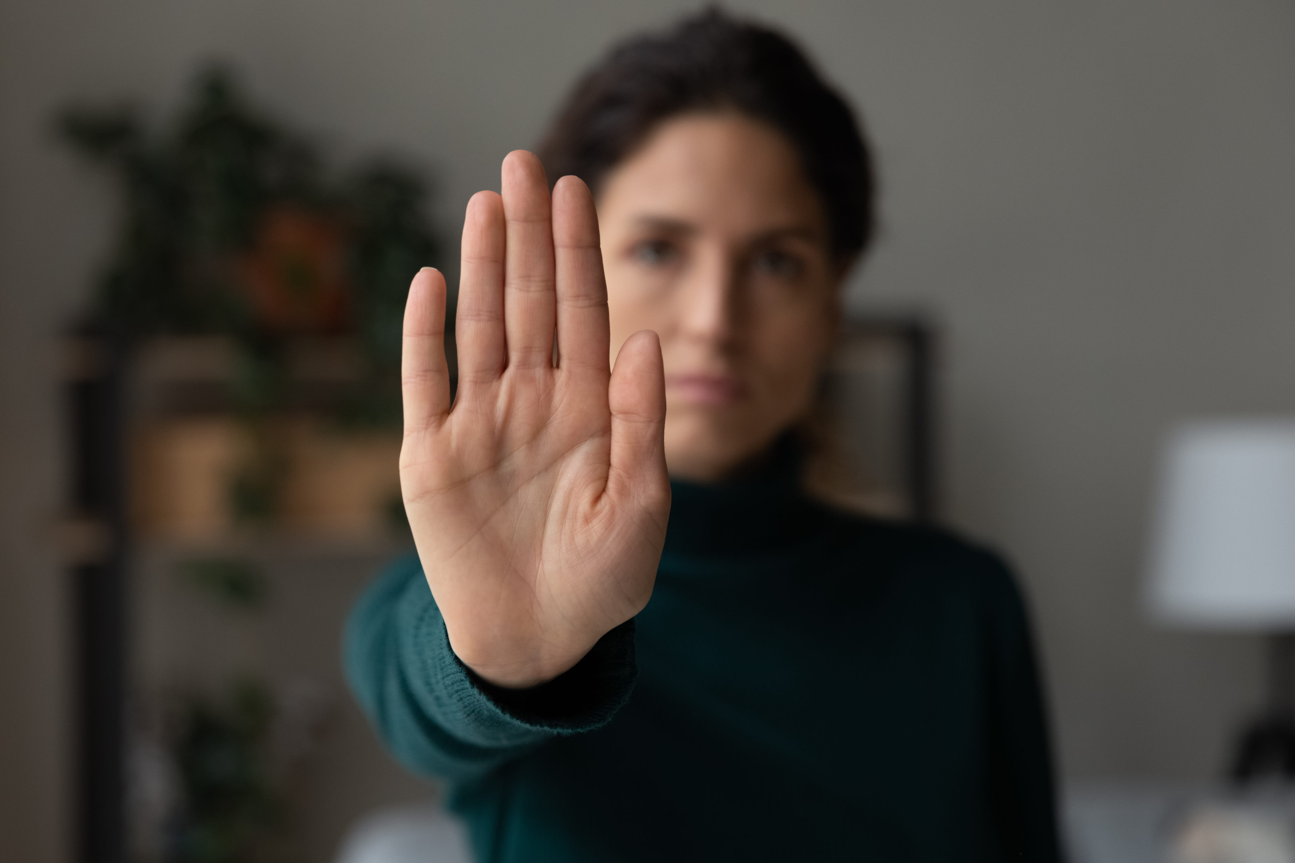Woman raising her hand to signal stop against harassment | Hemmat Law Group